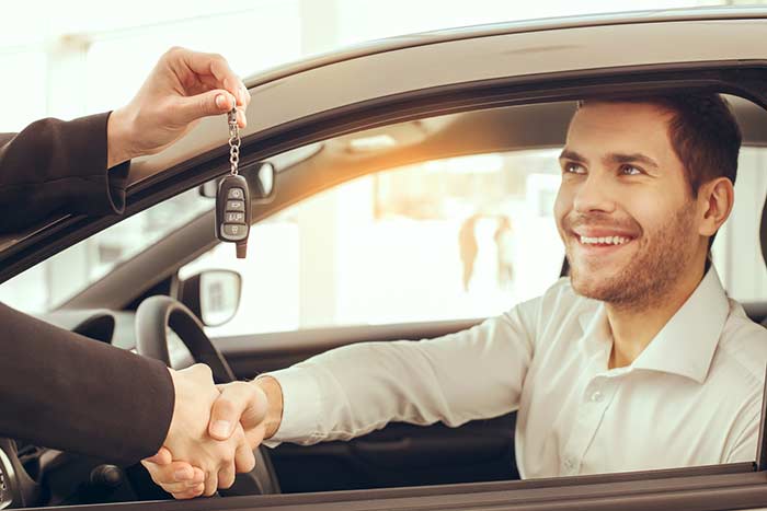 man handing keys for hire car